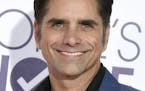 FILE - In this Jan. 18, 2017 file photo, John Stamos arrives at the People's Choice Awards at the Microsoft Theater in Los Angeles. Stamos will host t