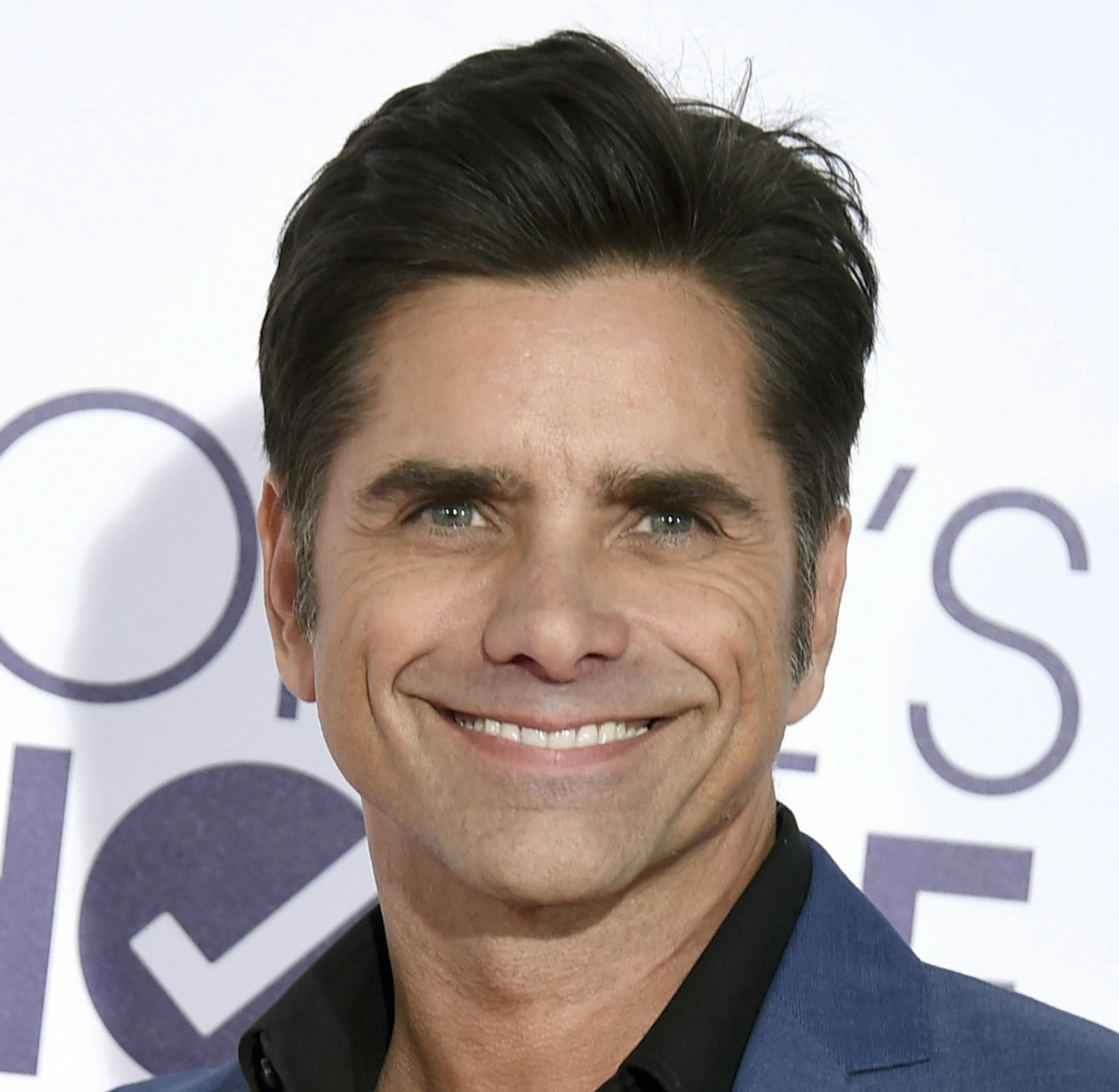 FILE - In this Jan. 18, 2017 file photo, John Stamos arrives at the People's Choice Awards at the Microsoft Theater in Los Angeles. Stamos will host the annual July Fourth concert outside the U.S. Capitol and pull double duty as the drummer for the Beach Boys. Organizers of the concert announced the lineup Tuesday, June 6, 2017. (Photo by Jordan Strauss/Invision/AP)