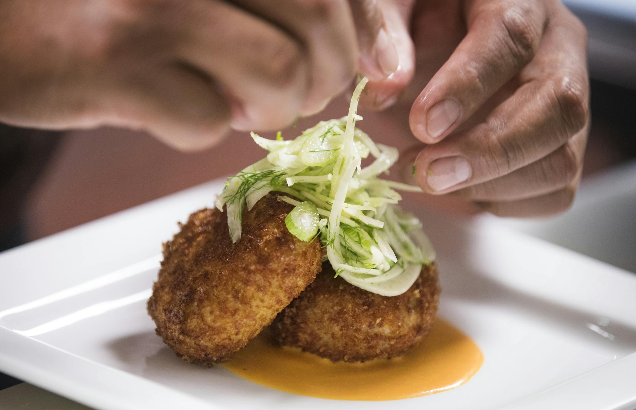 Ruiz applied the finishing touches to crab cakes.