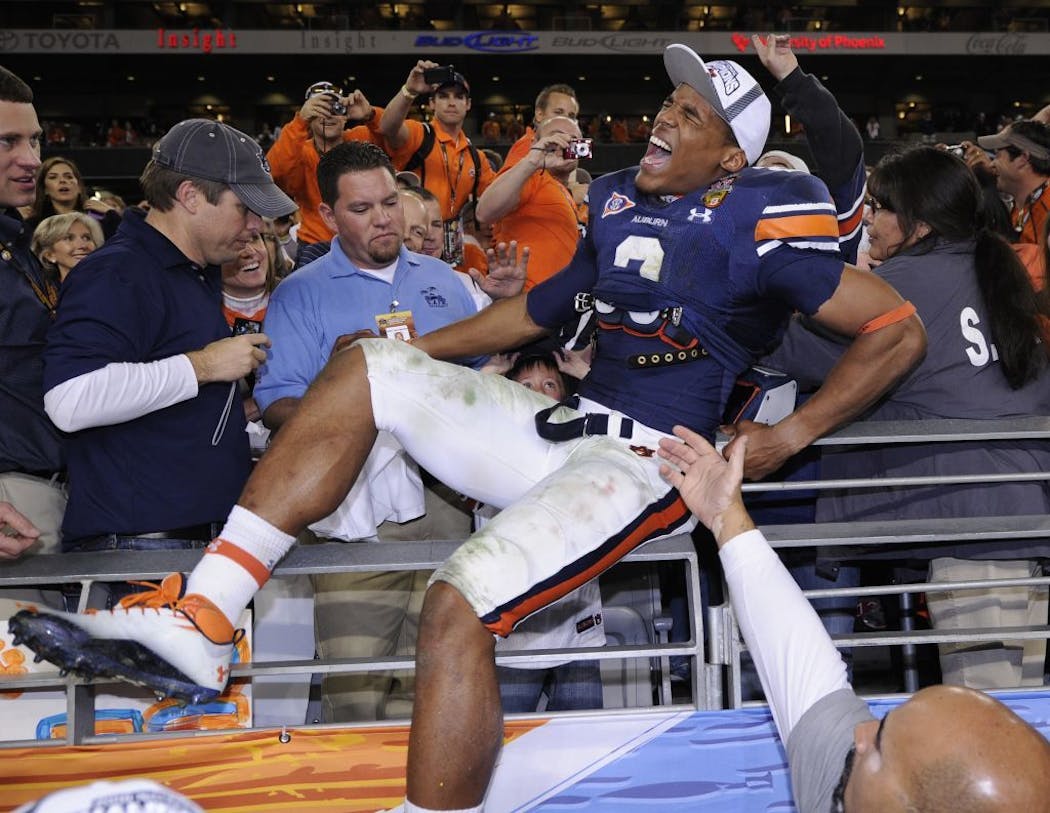 Cam Newton celebrates with fans after beating Oregon 22-19 in the BCS National Championship game to end the 2010 season.