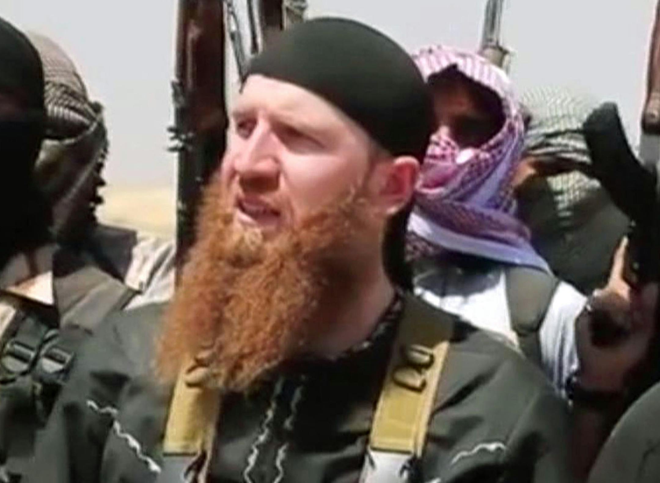 FILE - This image made from undated video posted during the weekend of June 28, 2014 on a social media account frequently used for communications by the Islamic State of Iraq and the Levant (ISIL), which has been verified and is consistent with other AP reporting, shows Omar al-Shishani standing next to the group's spokesman among a group of fighters as they declare the elimination of the border between Iraq and Syria. An Iraqi official and a Syrian activist say senior Islamic State group leader