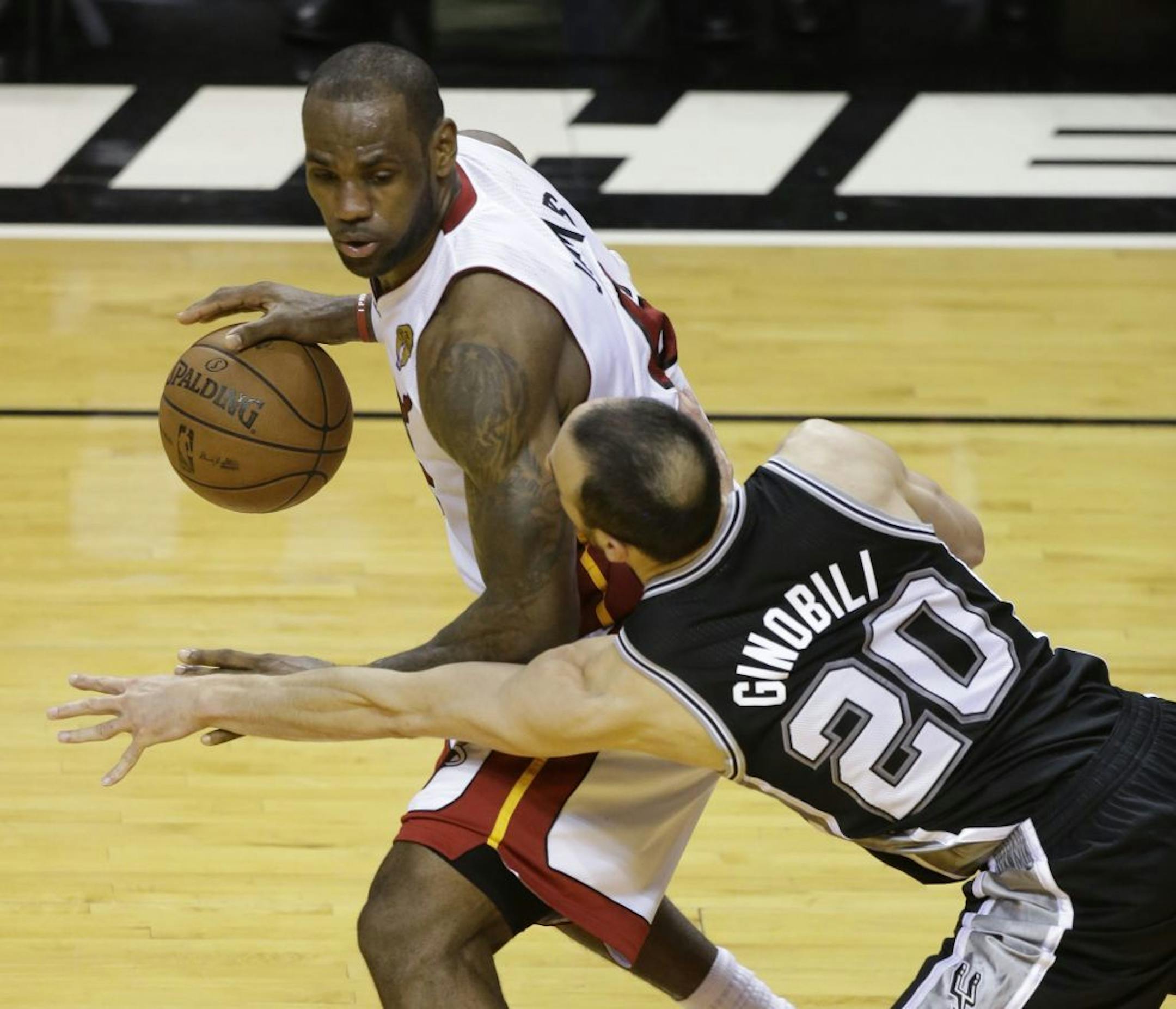 San Antonio Spurs guard Manu Ginobili (20) of Argentina defends Miami Heat forward LeBron James (6), during overtime in Game 6 of the NBA Finals basketball game, Wednesday, June 19, 2013 in Miami. The Heat defeated the Spurs 103-100.