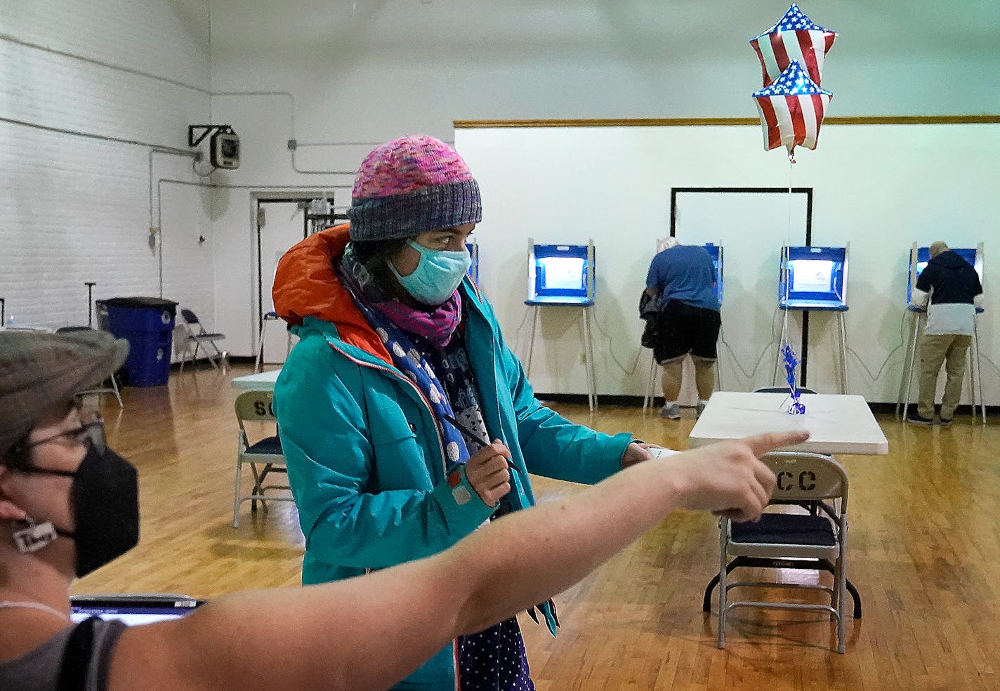 Monica Rojas gets directions from a poll worker on her way to casting her ballot at Sabathani Community Center during municipal elections Tuesday, Nov. 2, 2021, in Minneapolis, Minn. Voters in Minneapolis are deciding whether to replace the city's police department with a new Department of Public Safety. The election comes more than a year after George Floyd's death launched a movement to defund or abolish police across the country.(David Joles /Star Tribune via AP)