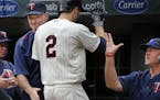 Brian Dozier(2) rounds the bases after he homers in the first inning and is greeted by manager Paul Molitor,left, and hitting coach Tom Brunansky, on 