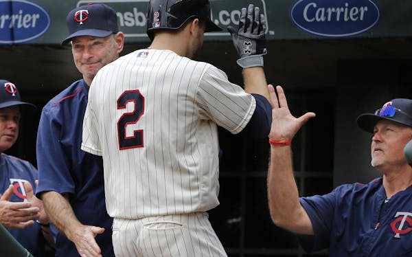Brian Dozier(2) rounds the bases after he homers in the first inning and is greeted by manager Paul Molitor,left, and hitting coach Tom Brunansky, on 
