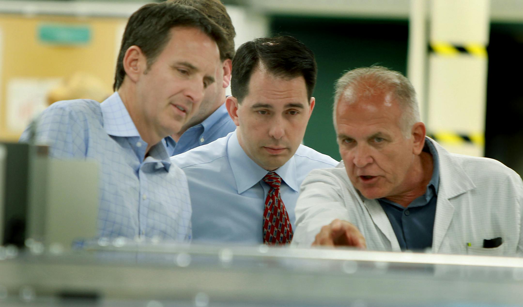 Wisconsin Governor Scott Walker received a lesson in screen printing by DuraTech Industries' employees Monday, May 21, 2012 during a tour of the Lacrosse, Wis., company alongside former Minnesota Governor Tim Pawlenty. Wisconsin Gov. Scott Walker is touring the state and visiting his Republican "Victory" Centers, where volunteers are manning phones and coordinating door-to-door efforts in the final weeks before the state's historical June 5 gubernatorial recall election.(ELIZABETH FLORES/STAR TR