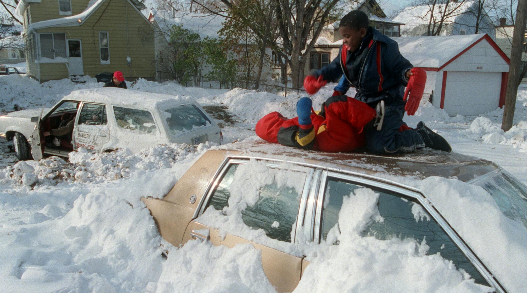 Kids played on top of a snowed-in car in Minneapolis after the Halloween blizzard of 1991.