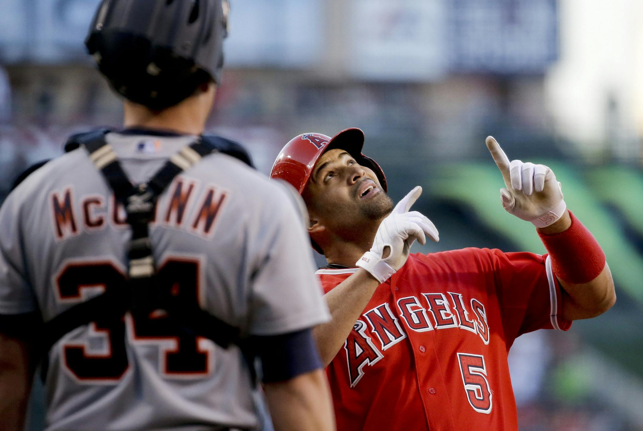 Detroit Tigers catcher James McCann, left, watches as Los Angeles Angels' Albert Pujols celebrates a two run home run during the first inning of a baseball game in Anaheim, Calif., Thursday, May 28, 2015. (AP Photo/Chris Carlson)