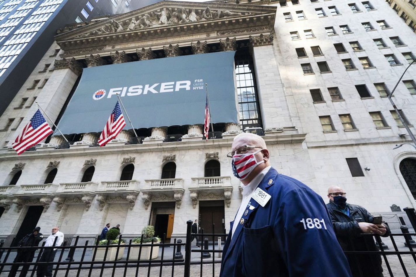 Stock trader Thomas Ferrigno arrives to work at the New York Stock Exchange, Monday, Nov. 9, 2020. World markets rocketed higher after Pfizer said early data show its coronavirus vaccine is effective. That added to investor relief that results from the U.S. presidential election were finally decided, with Joe Biden the president-elect.