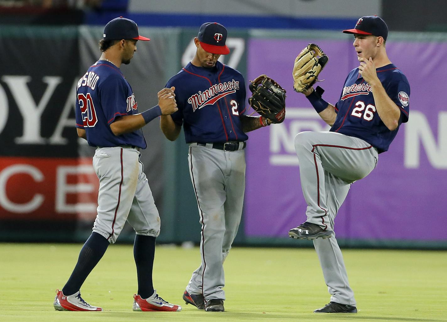 Minnesota Twins' Eddie Rosario (20), Byron Buxton (25) and Max Kepler (26) celebrate in the outfield after their 10-1 win over the Texas Rangers in a baseball game, Thursday, July 7, 2016, in Arlington, Texas. (AP Photo/Tony Gutierrez)