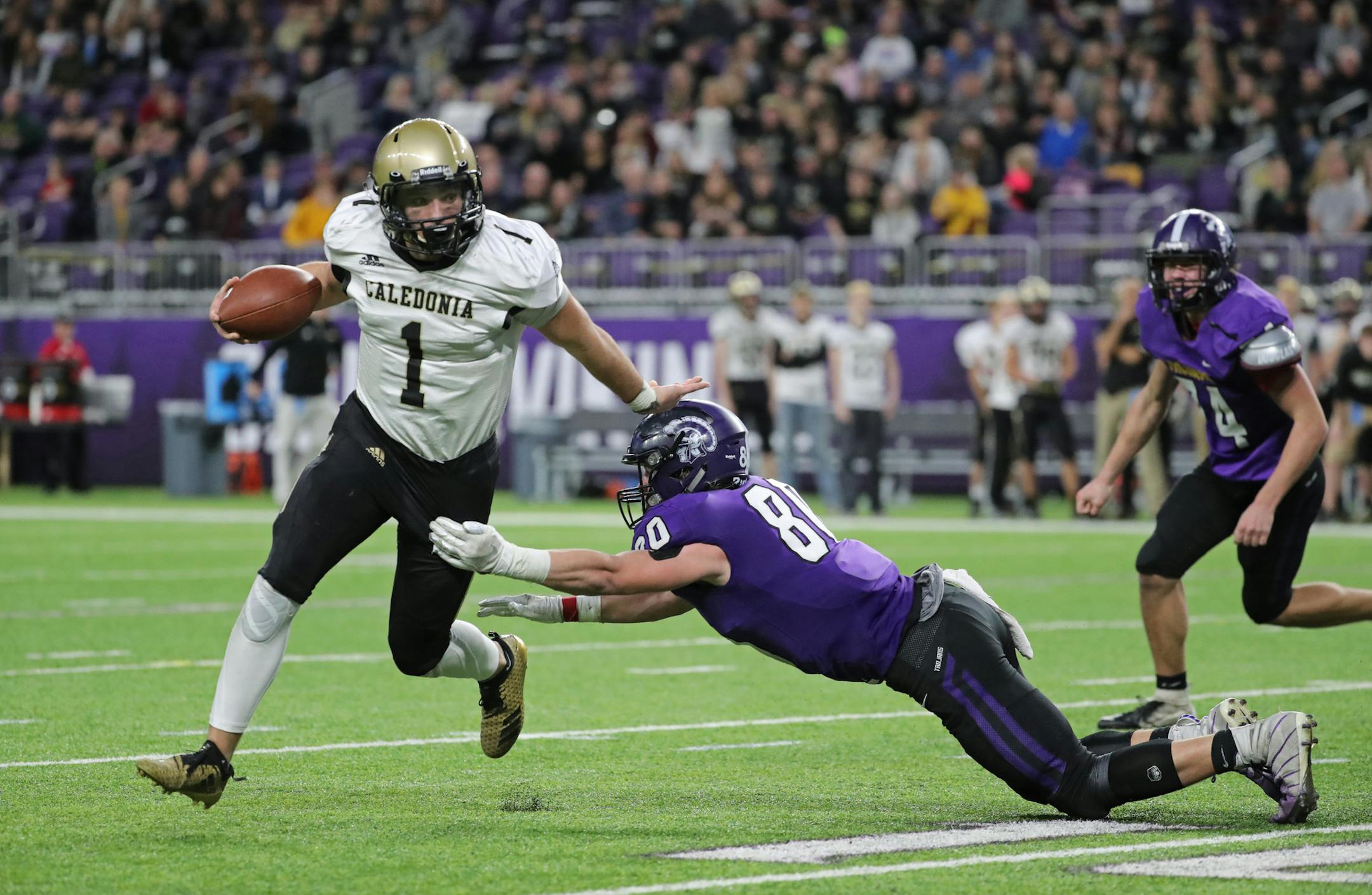 Caledonia quarterback Noah King (1) held off Barnesville defender Hunter Zenzen (80). ] Shari L. Gross ï shari.gross@startribune.com Caledonia shut out Barnesville 21-0 for their fourth consecutive class 2A championship inside U.S. Bank Stadium on Friday, Nov. 23, 2018