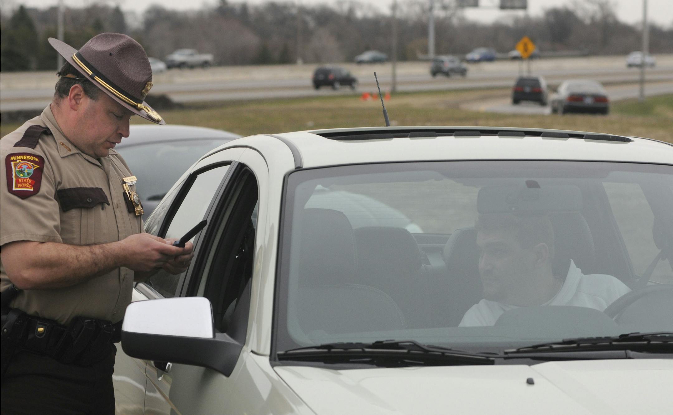 In this file photo from April 21, 2011, the Minnesota State Patrol targeted people who were texting while driving. Trooper Todd Merwin looked over a motorist's smart phone but let the driver go with a warning.