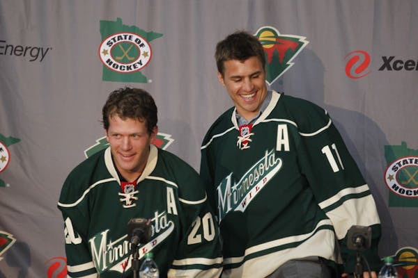 Ryan Suter, left, and Zach Parise sported their new Wild jerseys and fielded questions from the media after signing to play for the Wild.