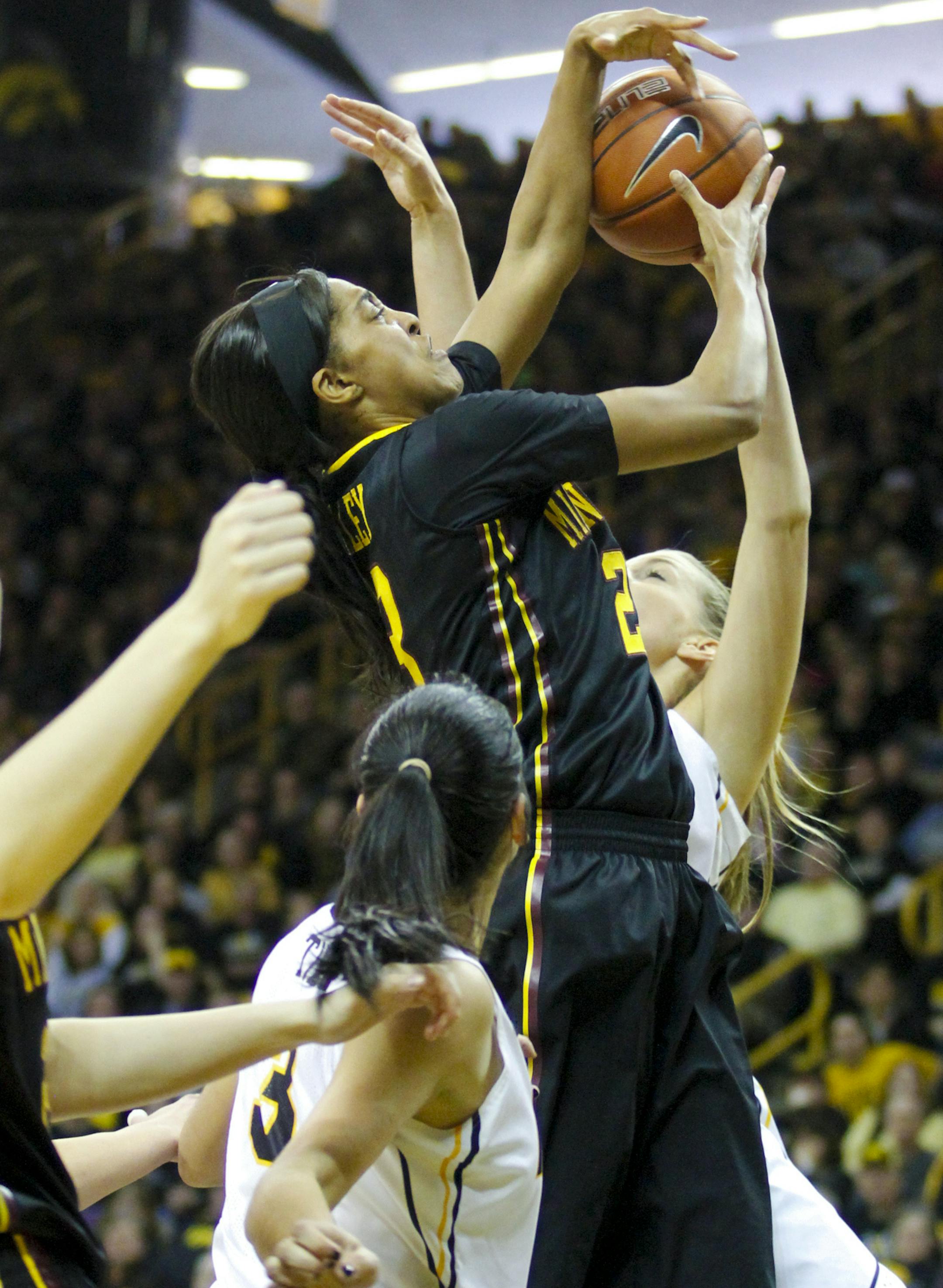Minnesota guard Shae Kelley, top, battles for a rebound with Iowa's Claire Till (3) and Whitney Jennings, right, during the second half of an NCAA college basketball game, Sunday, March 1, 2015, in Iowa City, Iowa. (AP Photo/Matthew Holst)