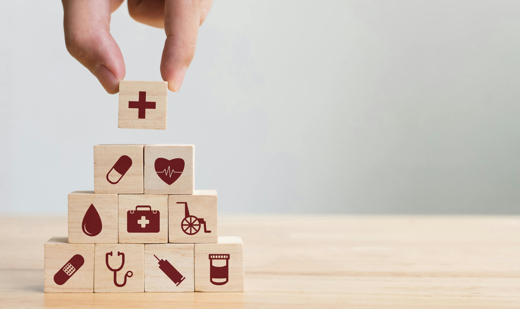 iStock
Hand arranging wood block stacking with icon healthcare medical, Insurance for your health concept