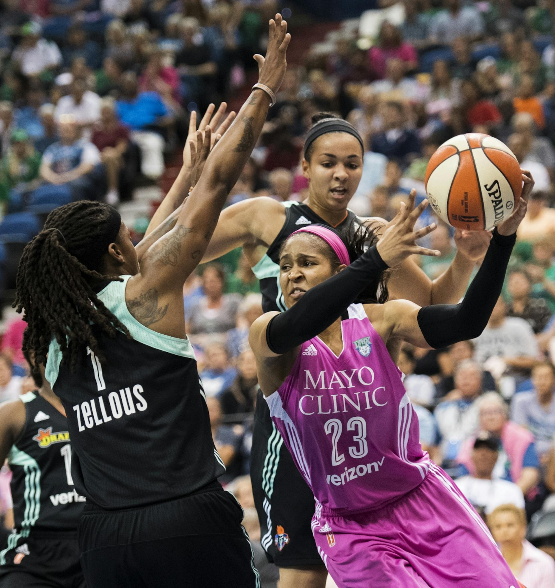 Minnesota Lynx forward Maya Moore (23) drove towards the basket by New York Liberty center Kiah Stokes (41) and guard Shavonte Zellous (1).