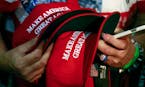 FILE - In this June 2, 2016, file photo, a woman holds hats to get them autographed by Republican presidential candidate Donald Trump during a rally i