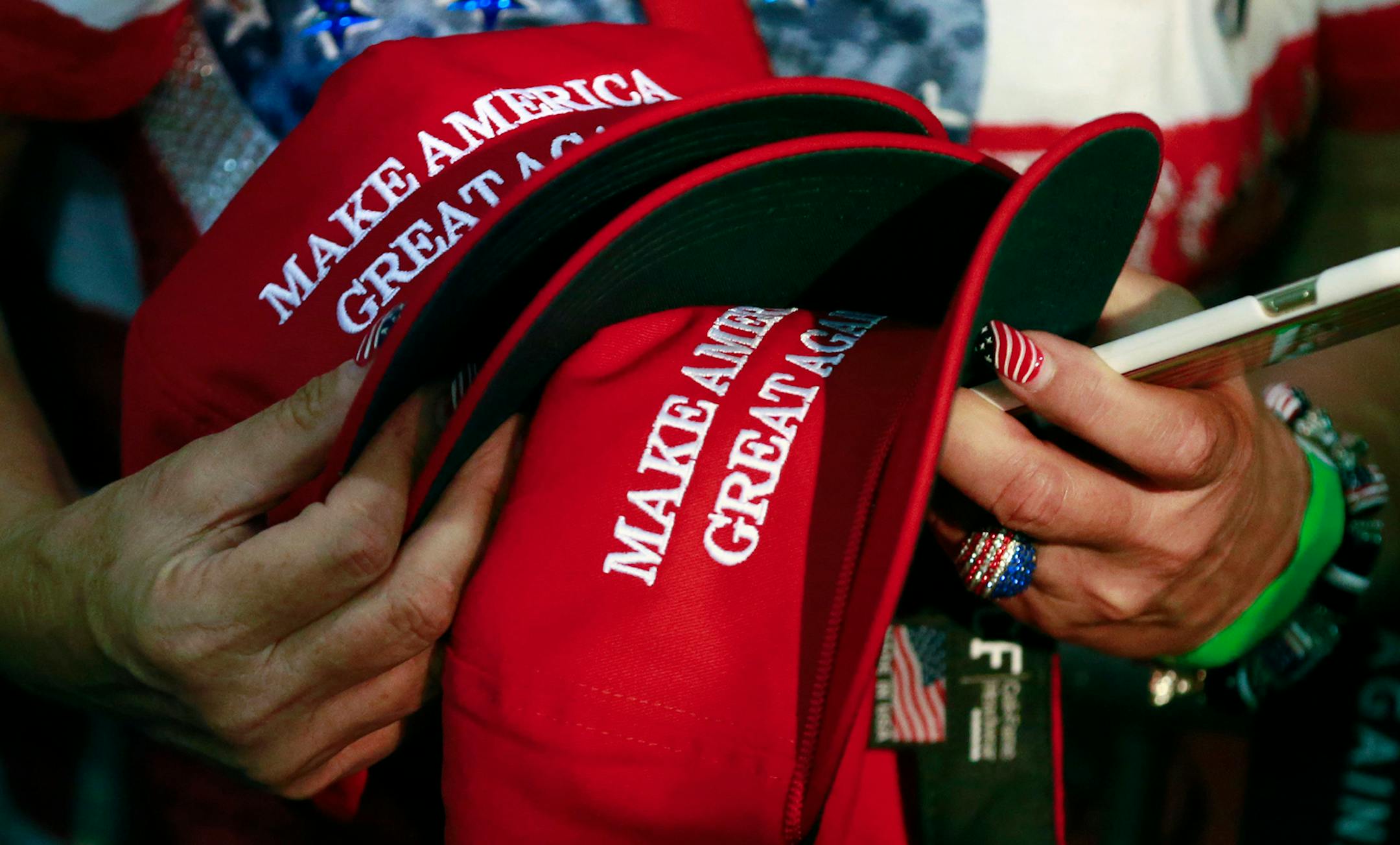 FILE - In this June 2, 2016, file photo, a woman holds hats to get them autographed by Republican presidential candidate Donald Trump during a rally in San Jose, Calif. Trump's "Make America Great Again" hats proudly tout they are "Made in USA." Not necessarily always the case, an Associated Press review found. (AP Photo/Jae C. Hong)