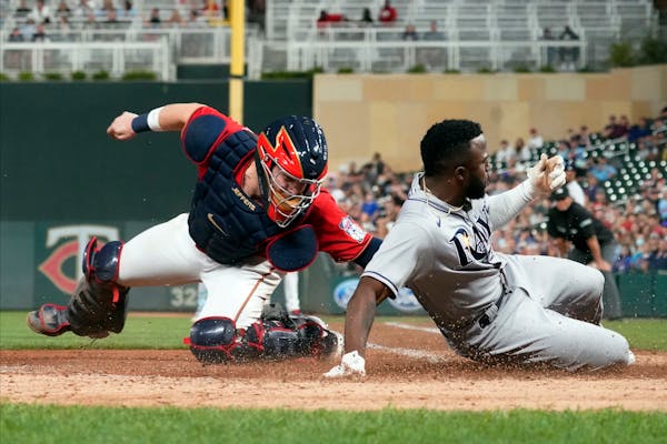 Tampa Bay Rays' Randy Arozarena, right, beats a tag by Minnesota Twins catcher Ryan Jeffers to score on a single by Kevin Kiermaier in the seventh inn