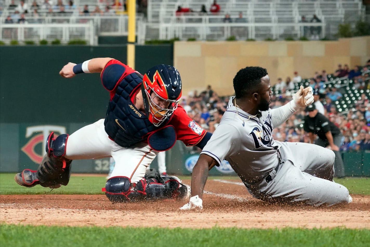 Tampa Bay Rays' Randy Arozarena, right, beats a tag by Minnesota Twins catcher Ryan Jeffers to score on a single by Kevin Kiermaier in the seventh inning of a baseball game, Friday, Aug. 13, 2021, in Minneapolis. (AP Photo/Jim Mone)