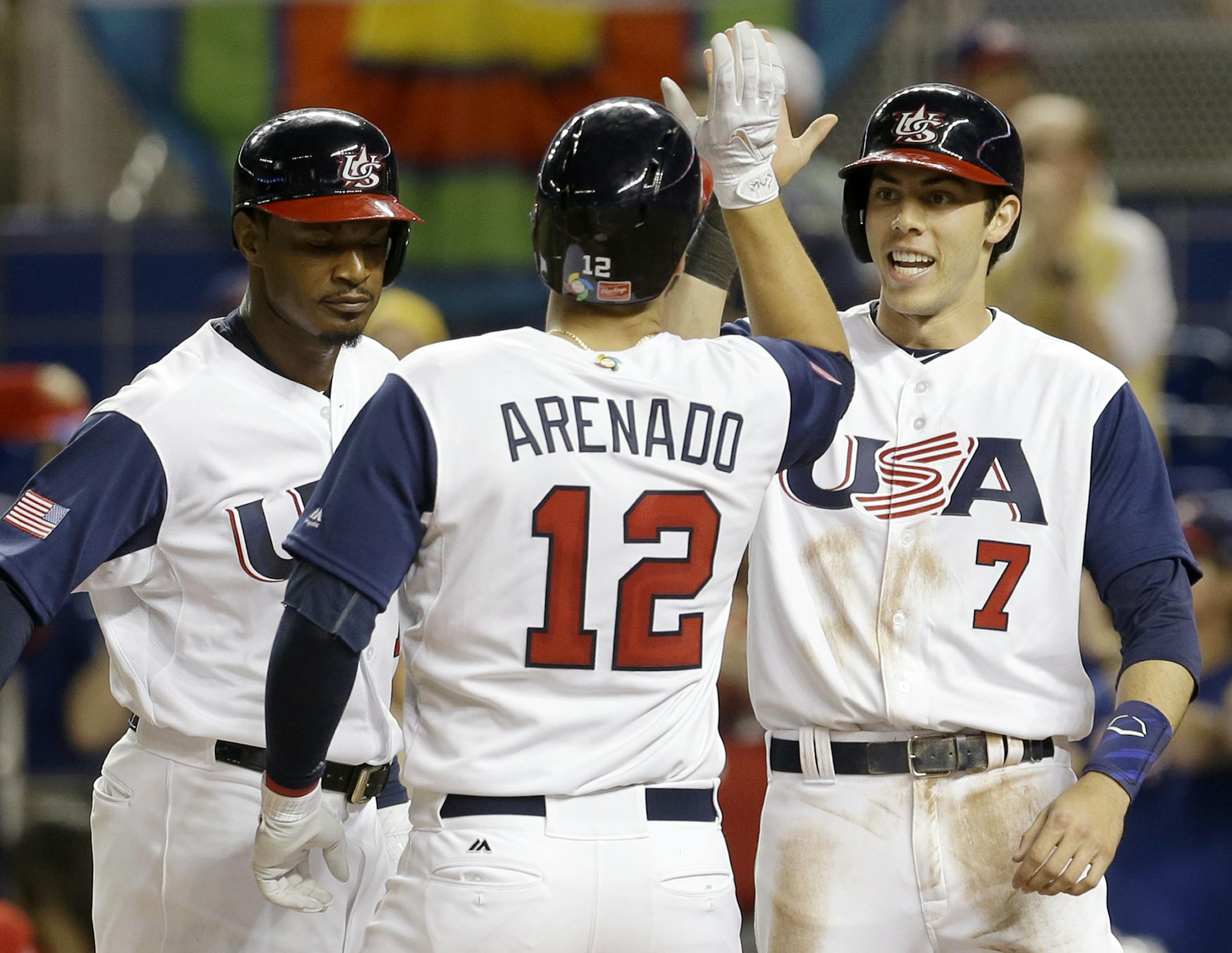 United States' Adam Jones, left, and Christian Yelich (7) congratulate teammate Nolan Arenado (12) after hitting a three-run home run against Canada in the second inning in a first-round game of the World Baseball Classic, Sunday, March 12, 2017, in Miami. (AP Photo/Alan Diaz)