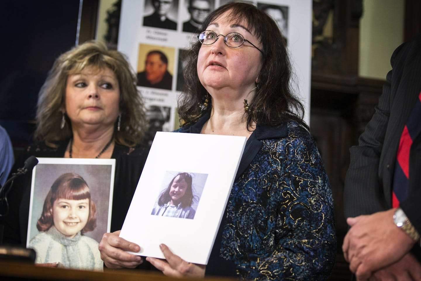 Lori Stoltz, one of the victims of deceased Diocese of New Ulm priest Fr. David Roney, holds a photo of herself at the age when she was abused as she speaks during a press conference at Jeff Anderson & Associates law office in St. Paul.