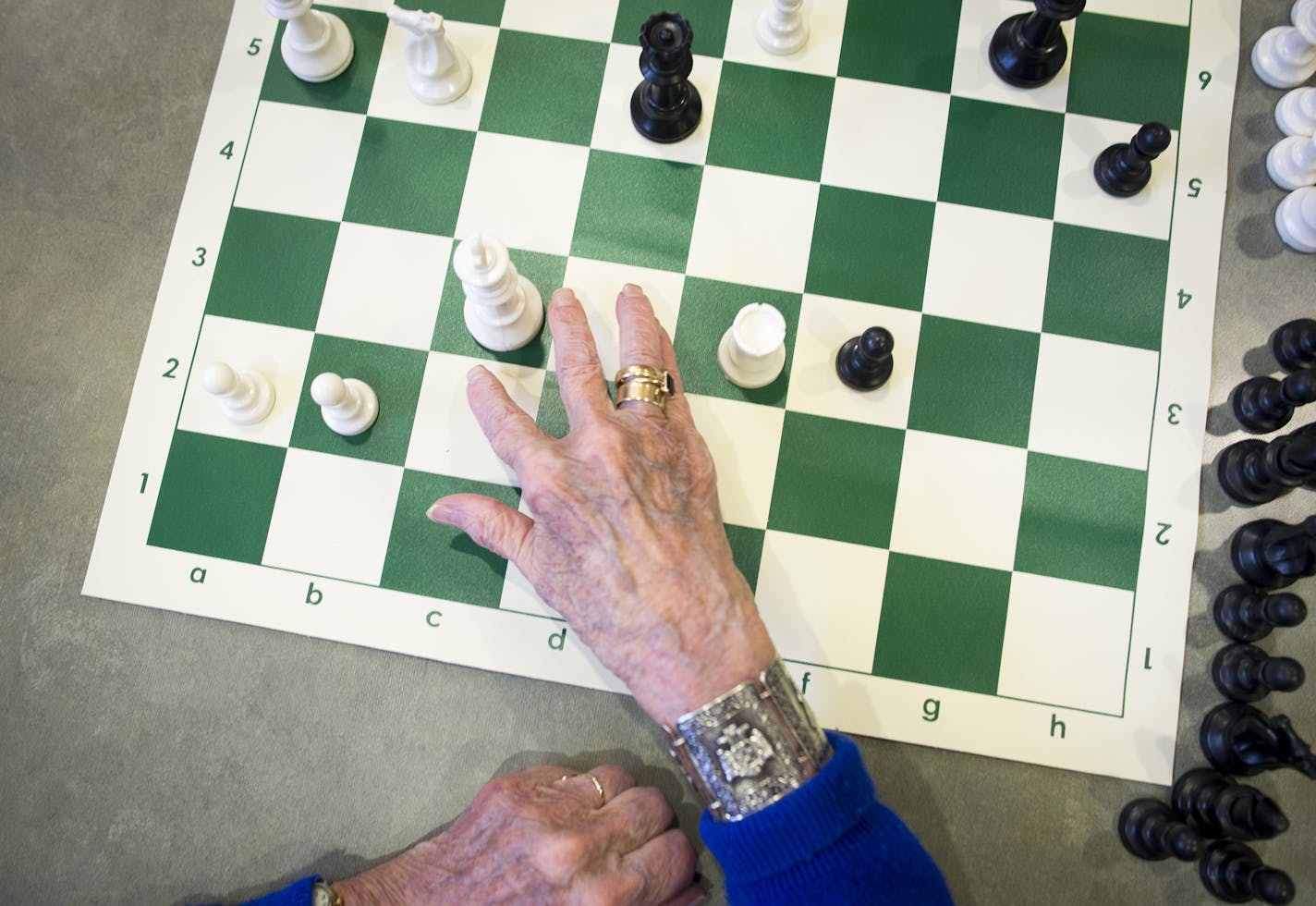 Friendship Village resident Helen McNulty moves her king during a chess class instructed by 17-year-old Connor Quinn on Tuesday afternoon. ] (Aaron Lavinsky | StarTribune) Elderly residents of Friendship Village of Bloomington are learning chess from 17-year-old kid. Connor Quinn,a junior at The Blake School and a chess expert, who last year, placed 30th at the U.S. Chess Federation National High School Chess Tournament.After Connor's grandfather died last year, he wanted to spend more time with