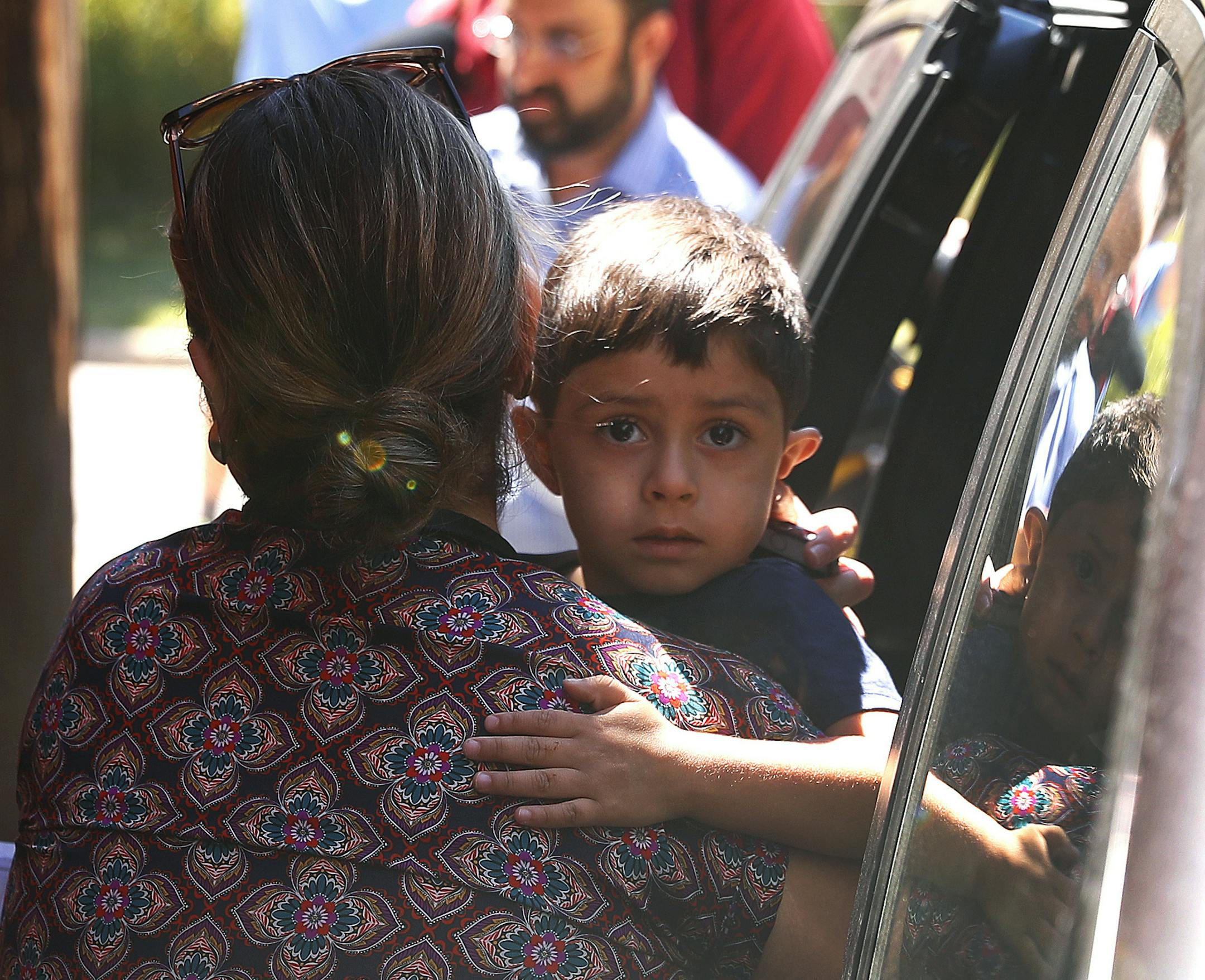 A child from Honduras is brought to the United States Immigration and Customs Enforcement office in Grand Rapids, Mich., Tuesday, July 10, 2018. Two boys and a girl who had been in temporary foster care in Grand Rapids have been reunited with their Honduran fathers after they were separated at the U.S.-Mexico border about three months ago. (AP Photo/Paul Sancya)