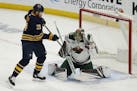 Buffalo Sabres forward Kyle Okposo (21) watches the puck go past Minnesota Wild goalie Devan Dubnyk (40) during the first period of an NHL hockey game