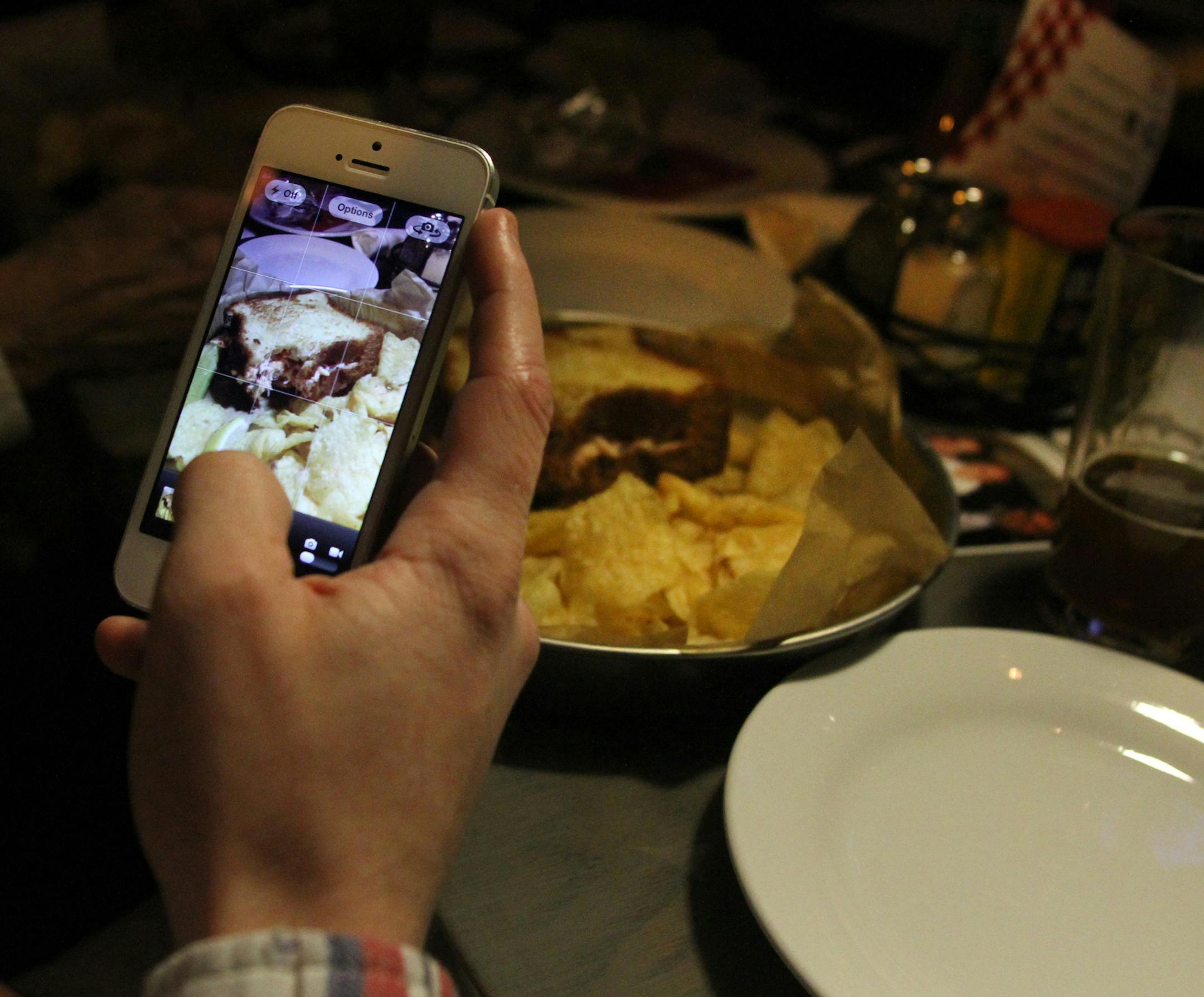 Shea Steacker used his iPhone to take a photo of his meal at the Smack Shack on Friday night. The Smack Shack held a grand opening on Friday, Febuary 8, 2013 in Minneapolis. ] NICOLA LOSIK* nicola.losik@startribune.com ORG XMIT: MIN1302102209280714