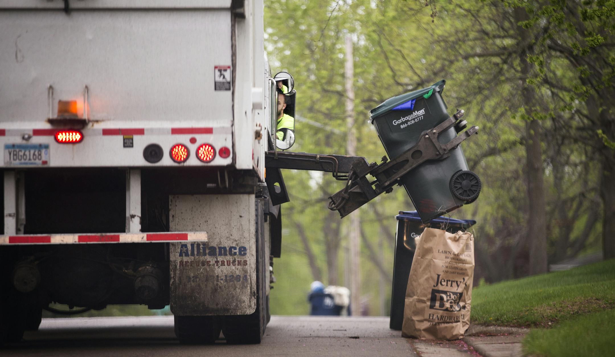 A GarbageMan worker empties containers onto the truck on trash pickup day in Bloomington between France Avenue and Normandale Boulevard on Thursday, May 7, 2015. ] LEILA NAVIDI leila.navidi@startribune.com / ORG XMIT: MIN1505071102290886