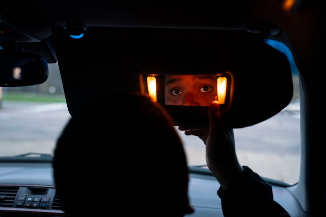 Latasha Bacon’s son Davonte, 13, looks at his mother through the front seat mirror while they complete DoorDash orders together in Blaine Friday. 