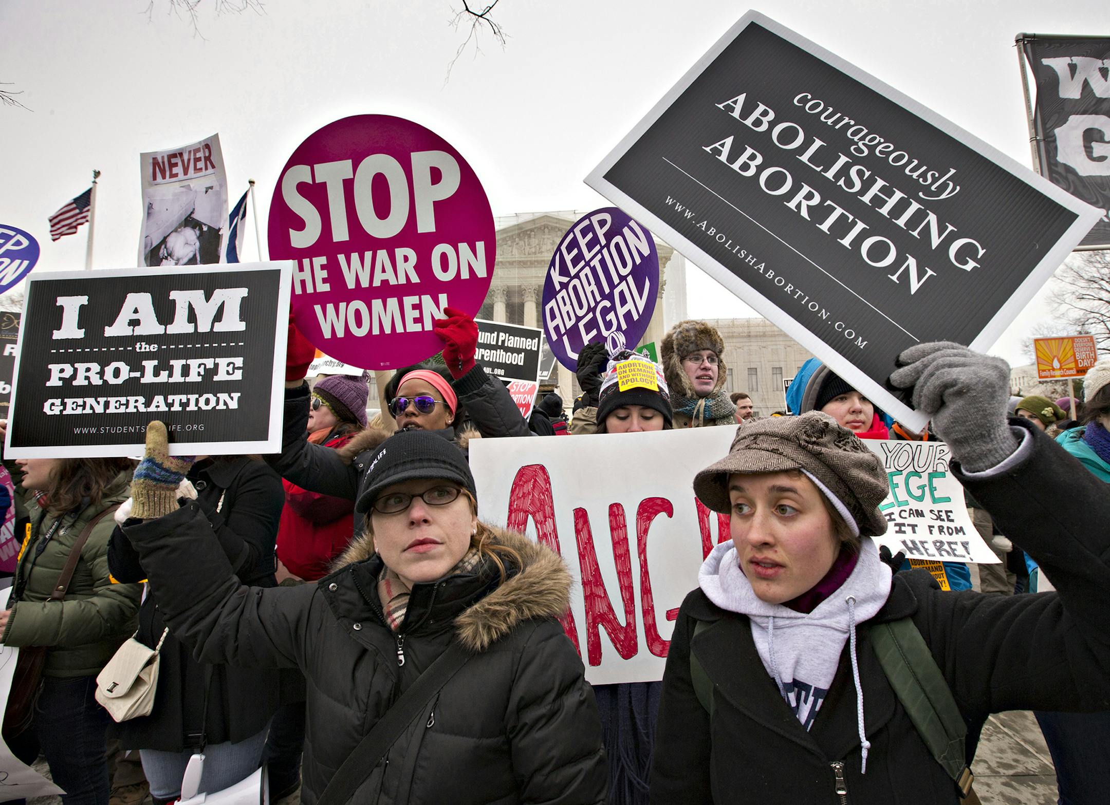 Anti-abortion activists and supporters of legal abortion stand in front of the Supreme Court in Washington, Friday, Jan. 25, 2013, on the 40th anniversary of the Roe v. Wade decision. Thousands of anti-abortion demonstrators marched through Washington to the steps of the U.S. Supreme Court to protest the landmark decision that legalized abortion. (AP Photo/J. Scott Applewhite) ORG XMIT: DCSA110 ORG XMIT: MIN1401141236411965