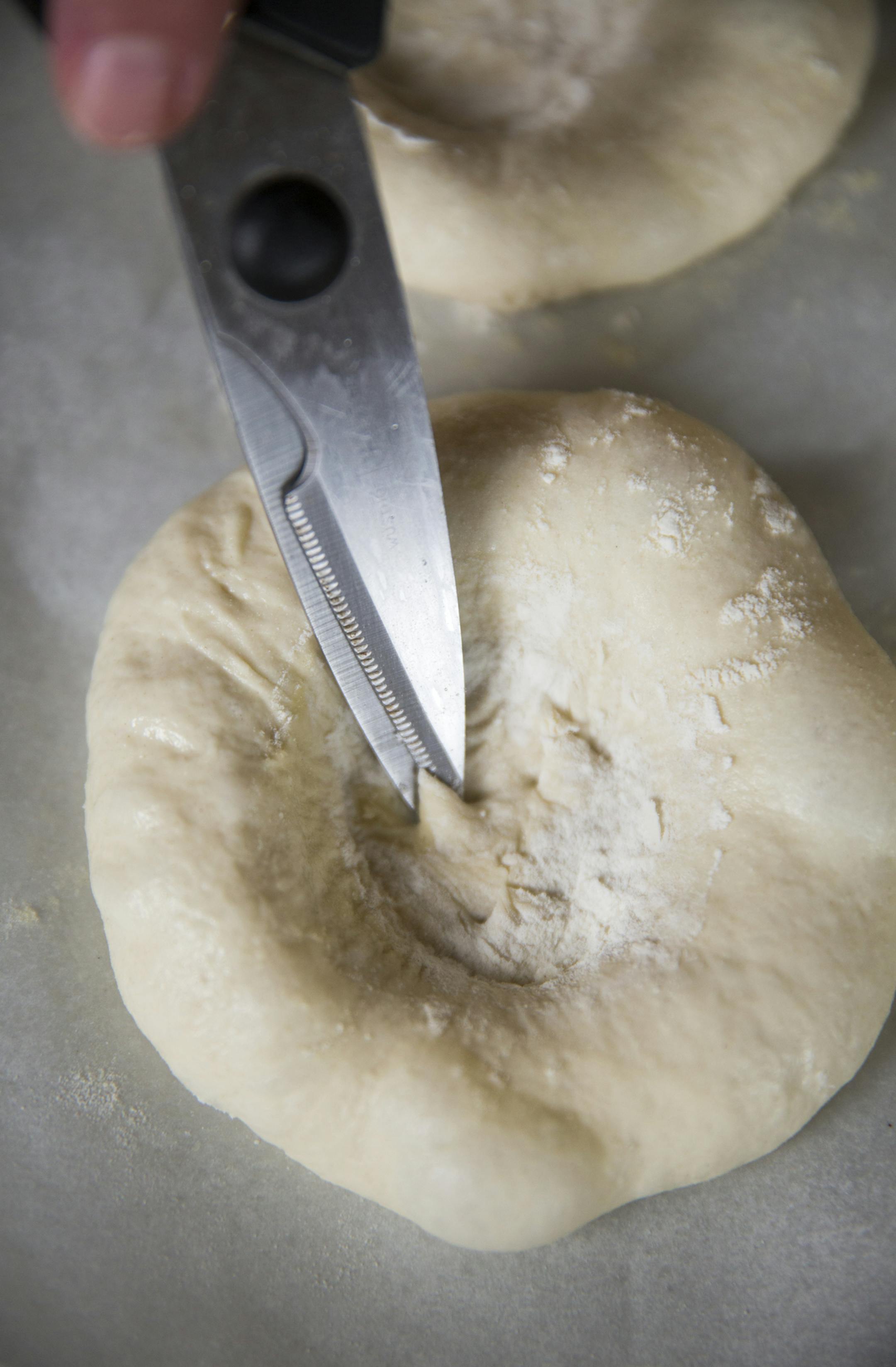 Cup little holes in the middle of the dough with scissors. ] (Leila Navidi/Star Tribune) leila.navidi@startribune.com BACKGROUND INFORMATION: Baking Central makes bialys, an onion and poppyseed filled bread of Eastern European fame, on Thursday, September 15, 2016.