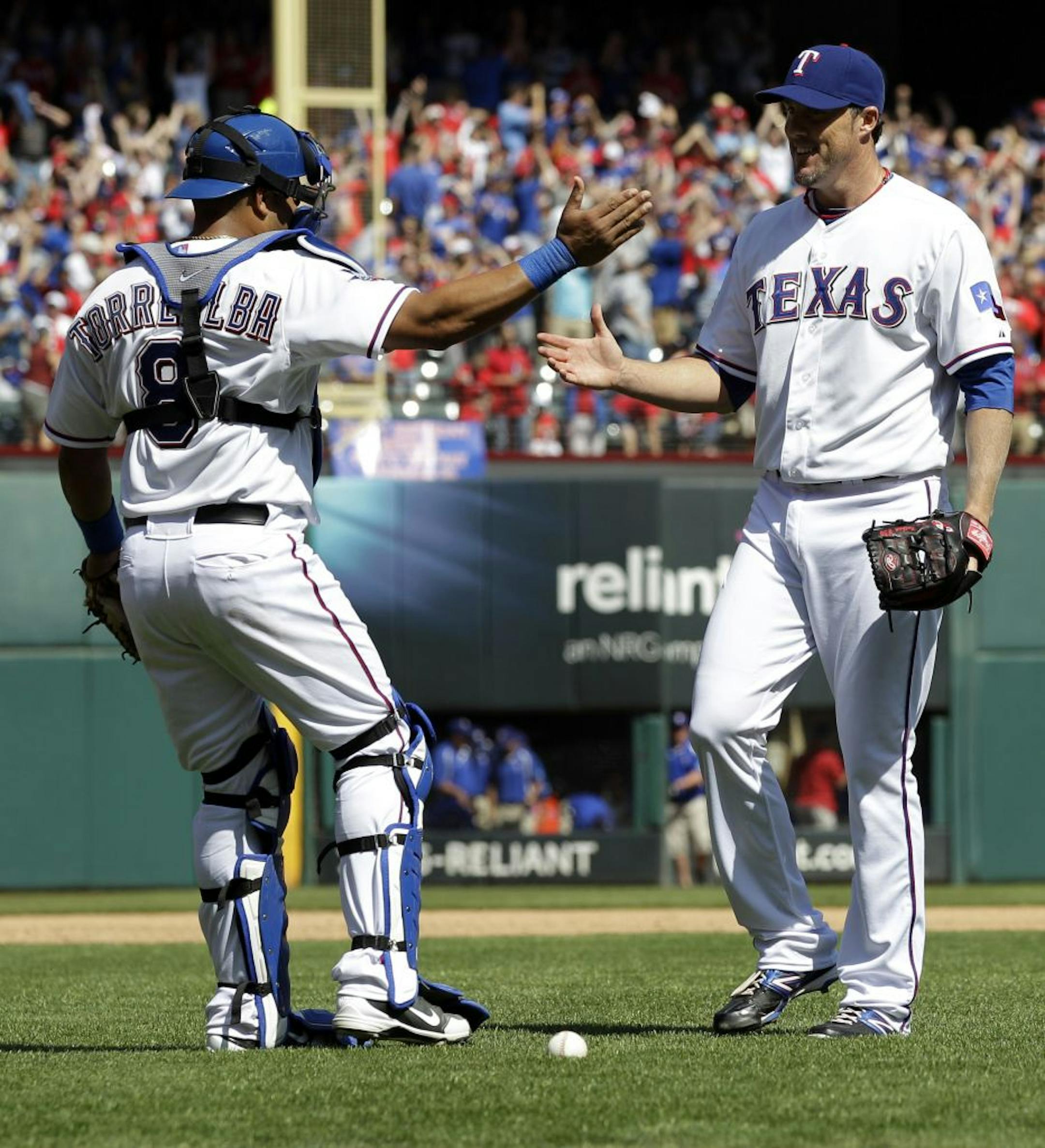 Texas Rangers catcher Yorvit Torrealba (8) and closer Joe Nathan (36) react after defeating the Chicago White Sox 3-2 in a baseball game, Friday, April 6, 2012, in Arlington, Texas.