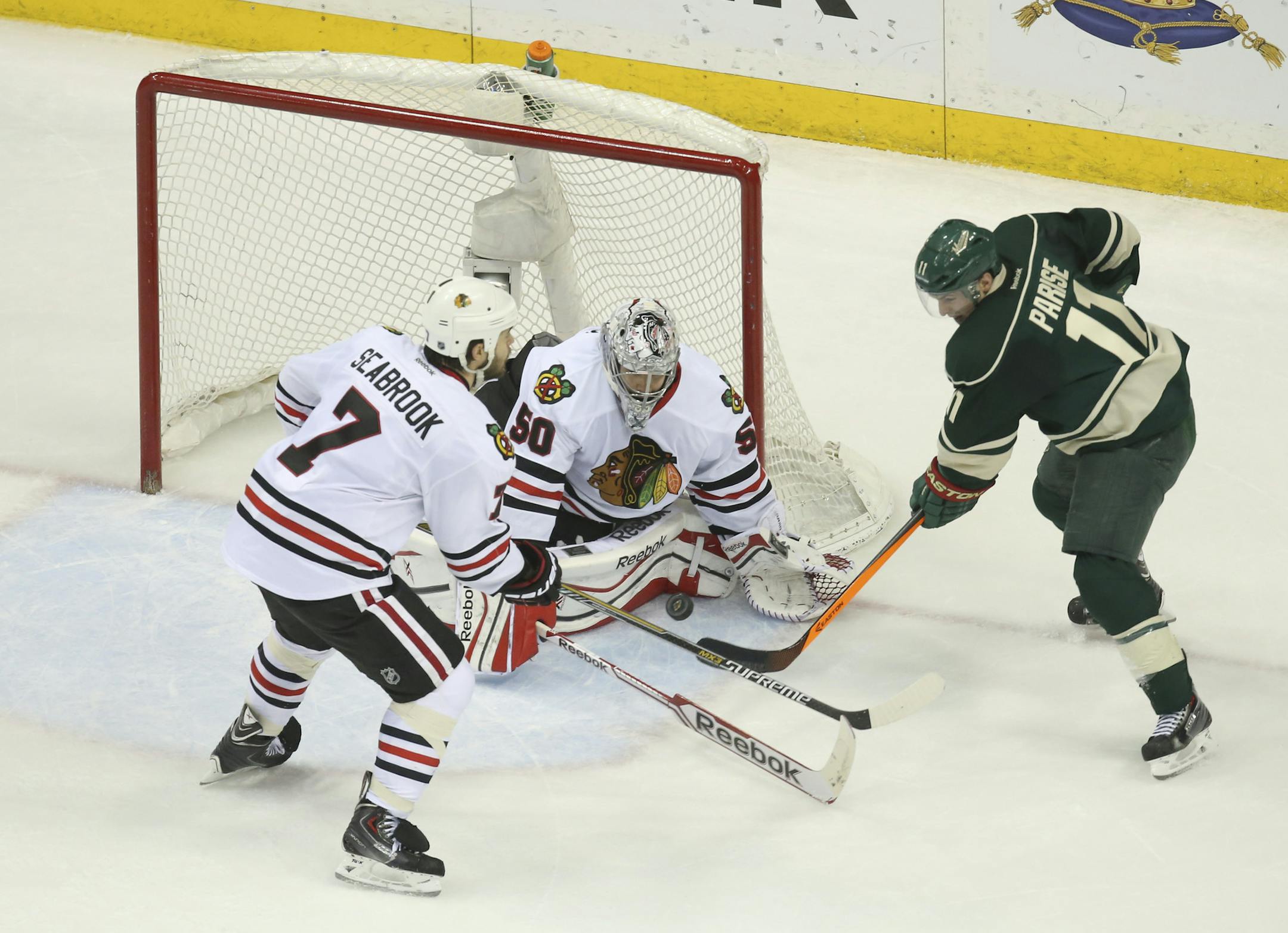 Minnesota Wild left wing Zach Parise (11) lifted the puck over the pads of Chicago Blackhawks goalie Corey Crawford (50) before being checked by defenseman Brent Seabrook (7) in the second period of their game Tuesday night at Xcel Energy Center in St. Paul. ] JEFF WHEELER ‚Ä¢ jeff.wheeler@startribune.com The Minnesota Wild faced the Chicago Blackhawks in game 6 of their playoff series Monday night, May 13, 2014 at Xcel Energy Center in St. Paul.