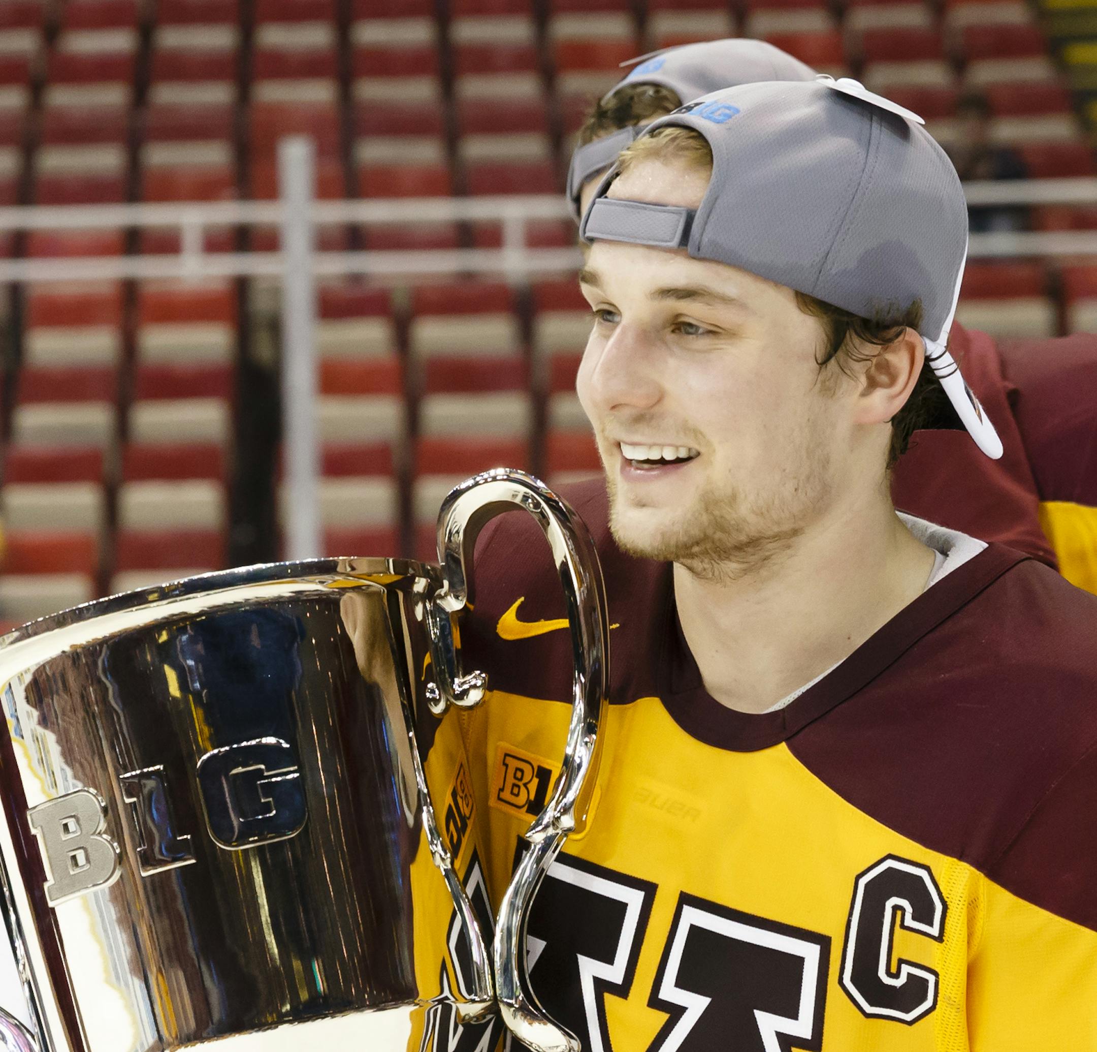 Minnesota's Kyle Rau (7) holds the the Big Ten Championship trophy after an NCAA college hockey game against Michigan, Saturday, March 21, 2015, in Detroit. Minnesota defeated Michigan 4-2 to win the Big Ten Championship tournament. (AP Photo/Rick Osentoski)