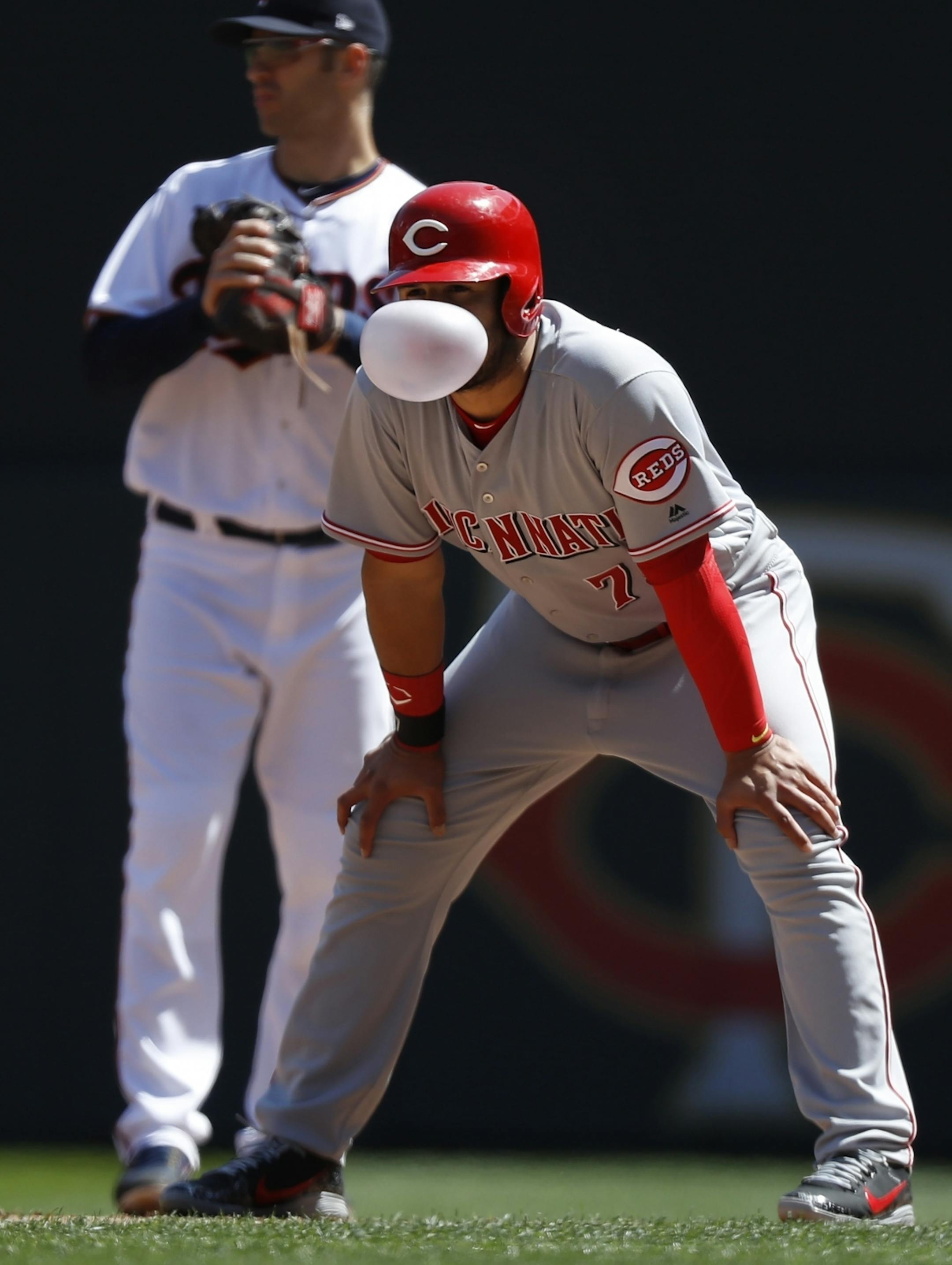 Eugene Suarez(7) blows a bubble as Joe Mauer holds him to 1B.