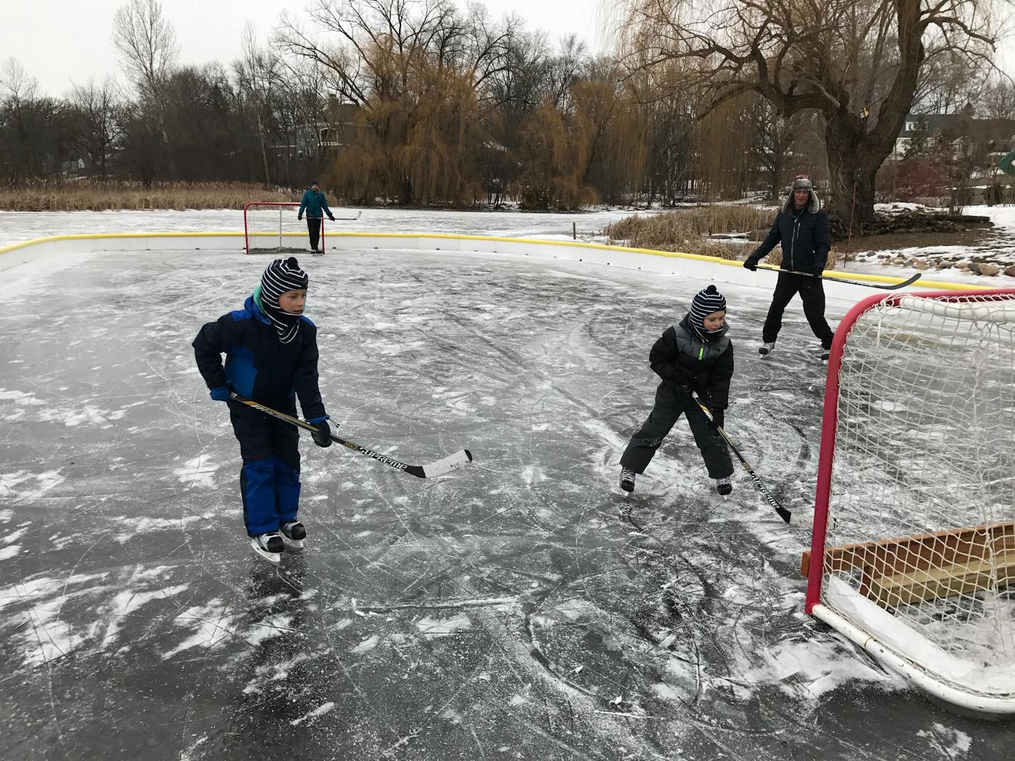 Parker, 7, and Levi, 5, Staal skate in the backyard rink with their uncle Geoff Lindberg and grandfather Arthur Vandenbroeke. photo courtesy the Staal family