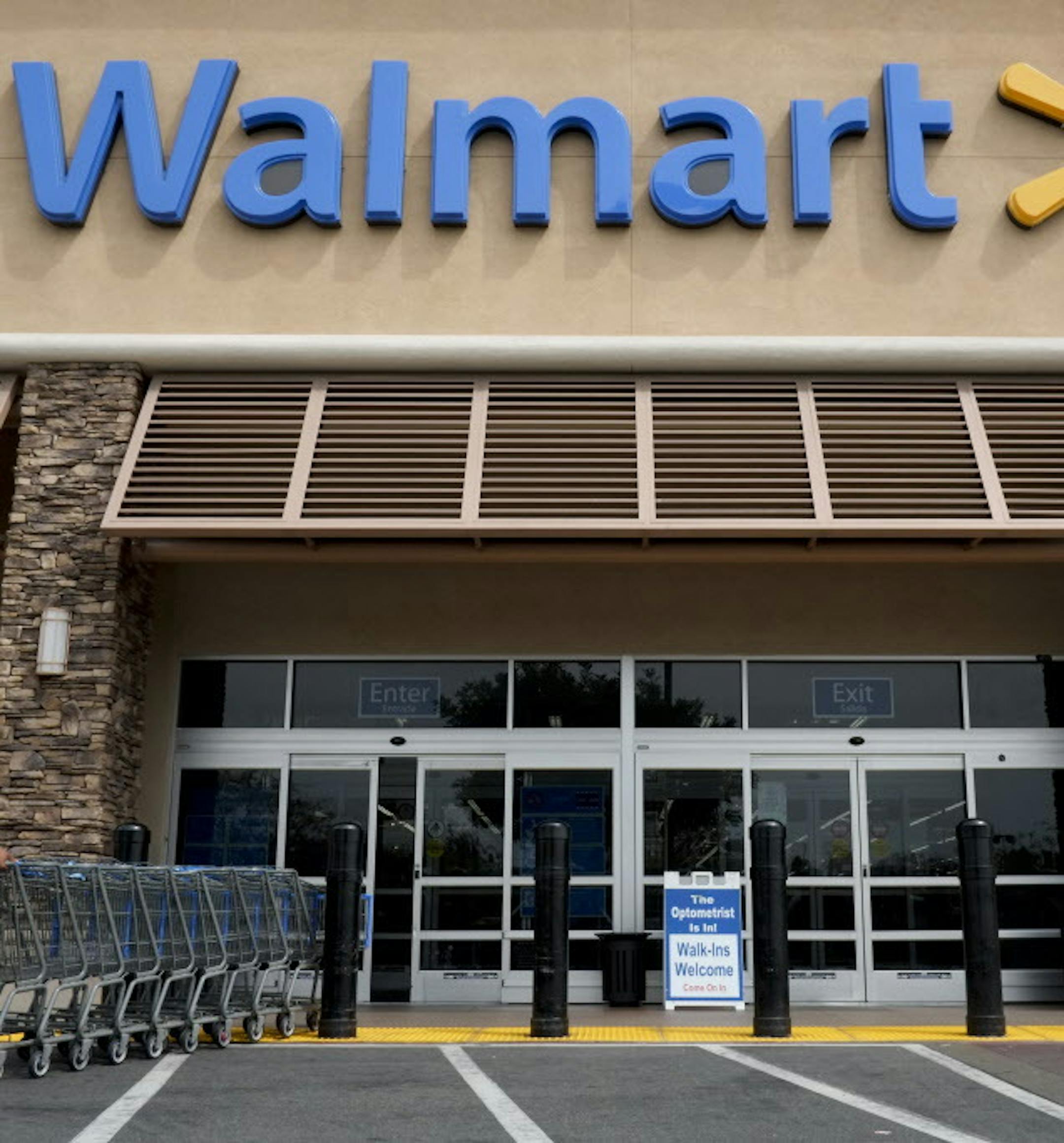 FILE - In this May 9, 2013, file photo, a worker pushes shopping carts in front of a Wal-Mart store in La Habra, Calif. Wal-Mart plans to add about 10,000 retail jobs in the U.S. as it opens new stores and expands existing locations. The world's biggest retailer said Tuesday, Jan. 17, 2017, that there will also be about 24,000 construction jobs as well. (AP Photo/Jae C. Hong, File)
