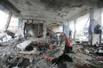 Palestinians look at the aftermath of the Israeli strike on a U.N.-run school that killed dozens of people in the Nusseirat refugee camp in the Gaza S