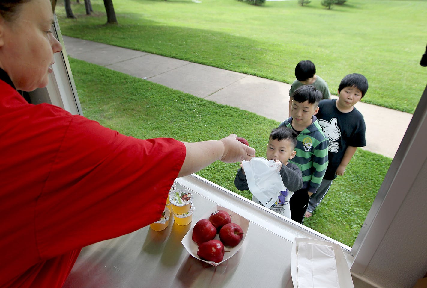 St. Paul public schools cafeteria personnel Nancy Hengel handed out free meals to kids at Lewis Park, Monday, June 15, 2015 in St. Paul, MN.