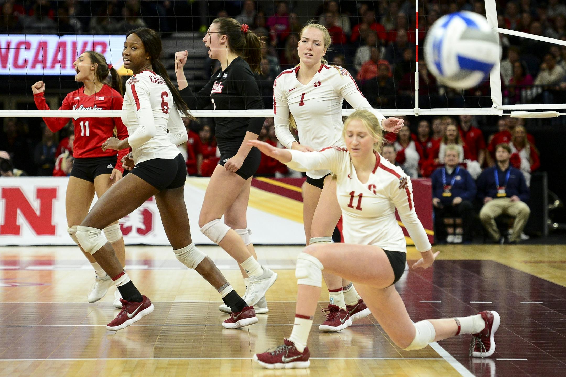 Nebraska players, including outside hitter Mikaela Foecke (2), wearing black, celebrated after an early first set point against Stanford Saturday night.