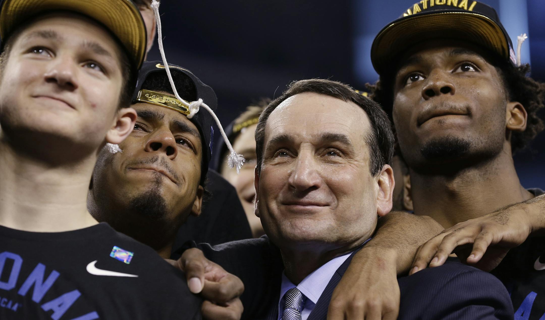 Duke head coach Mike Krzyzewski watches the One Shining Moment tribute with his team after their 68-63 victory over Wisconsin in the NCAA Final Four college basketball tournament championship game Monday, April 6, 2015, in Indianapolis. (AP Photo/David J. Phillip)