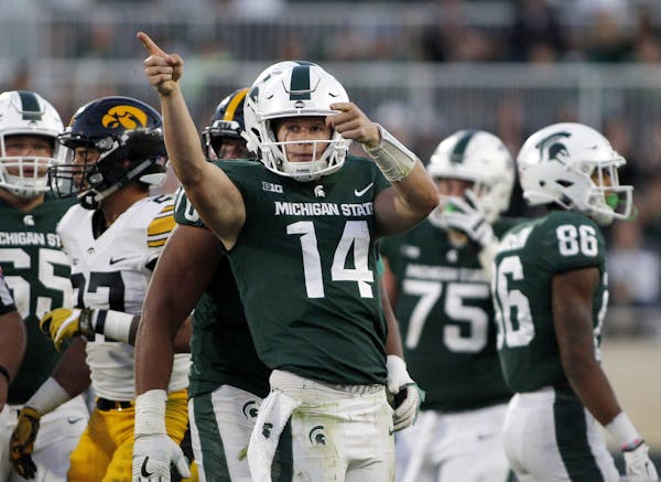 Michigan State quarterback Brian Lewerke (14) reacts after running for a first down against Iowa late in the fourth quarter of an NCAA college footbal