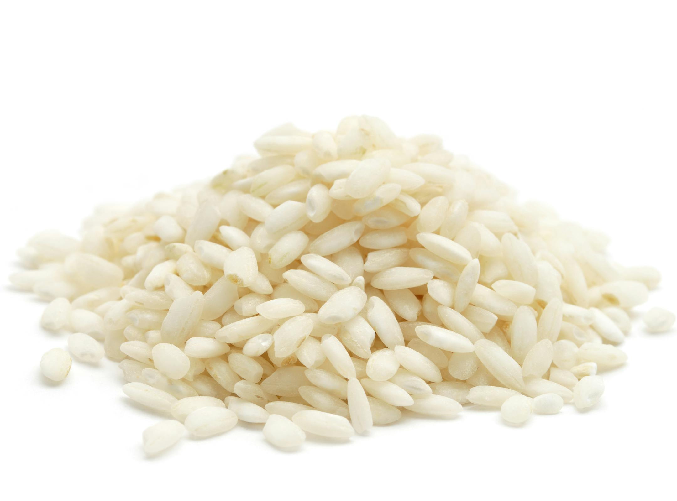Arborio Rice used for making risotto in a heap isolated on a white background.