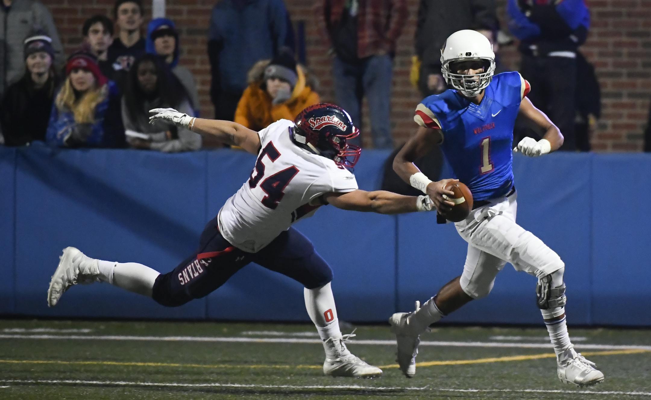 SMB Wolfpack quarterback Jalen Suggs (1) looked to pass the ball downfield while being chased down by Orono offensive lineman David Wilfert (54) in the first quarter. ] Aaron Lavinsky • aaron.lavinsky@startribune.com Orono played the SMB Wolfpack in a Class 4A, Section 5 football semifinal game on Saturday, Oct. 27, 2018 at The Blake School in Hopkins, Minn.