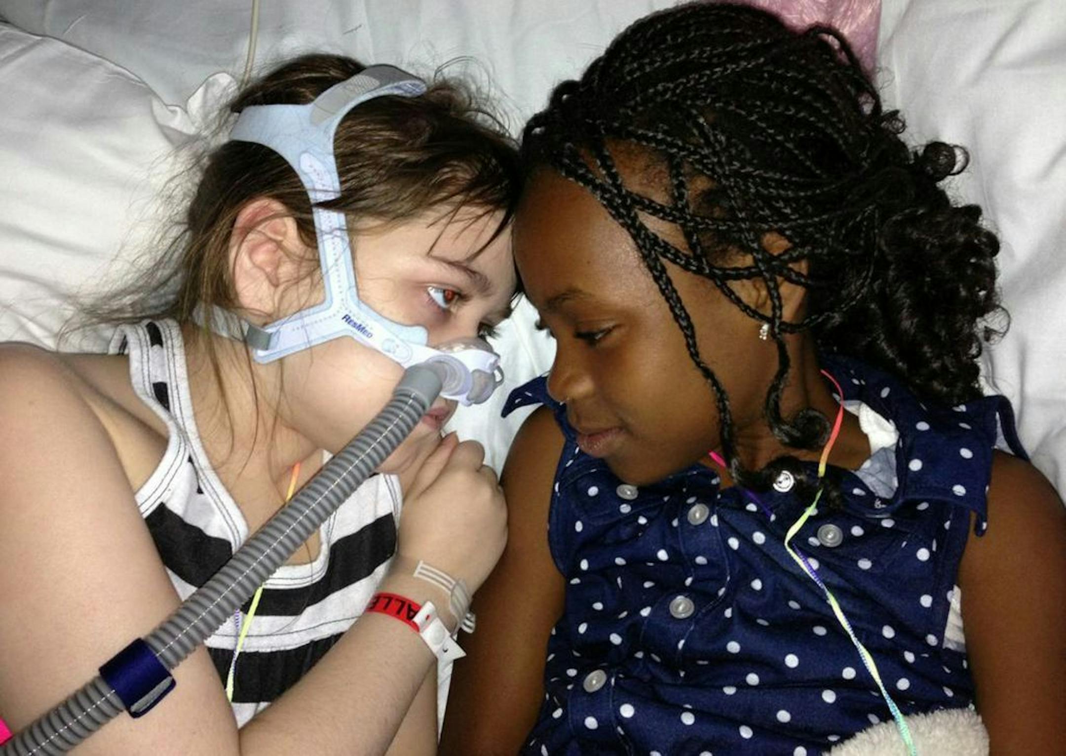 In this May 30, 2013 file photo provided by the Murnaghan family, Sarah Murnaghan, left, lies in her hospital bed next to adopted sister Ella on the 100th day of her stay in Children's Hospital of Philadelphia.
