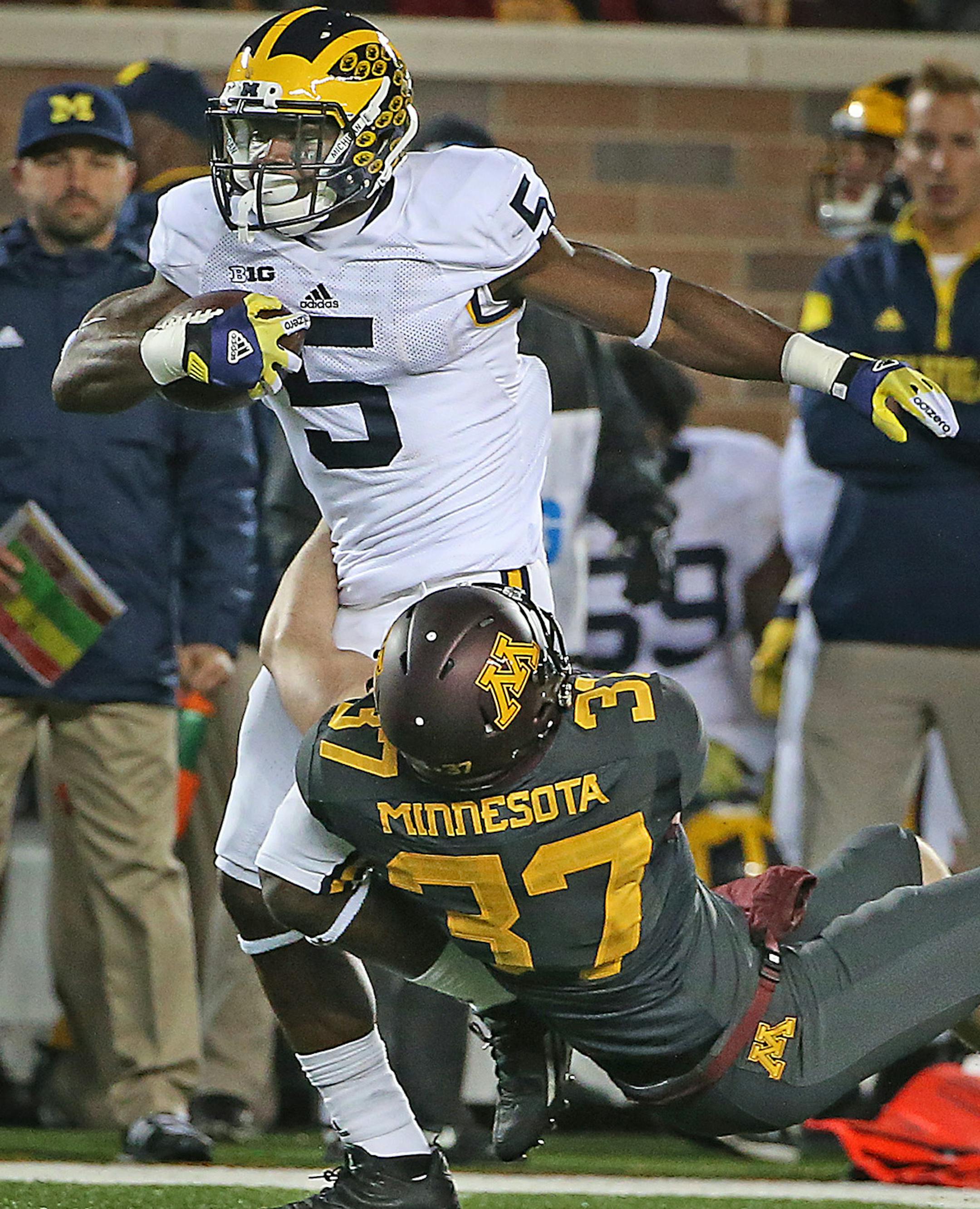 Michigan's Jabrill Peppers carried the ball despite defensive pressure by Minnesota's punter Peter Mortell in the second quarter as Minnesota took on Michigan at TCF Bank Stadium, Saturday, October 31, 2015 in Minneapolis, MN. ] (ELIZABETH FLORES/STAR TRIBUNE) ELIZABETH FLORES • eflores@startribune.com