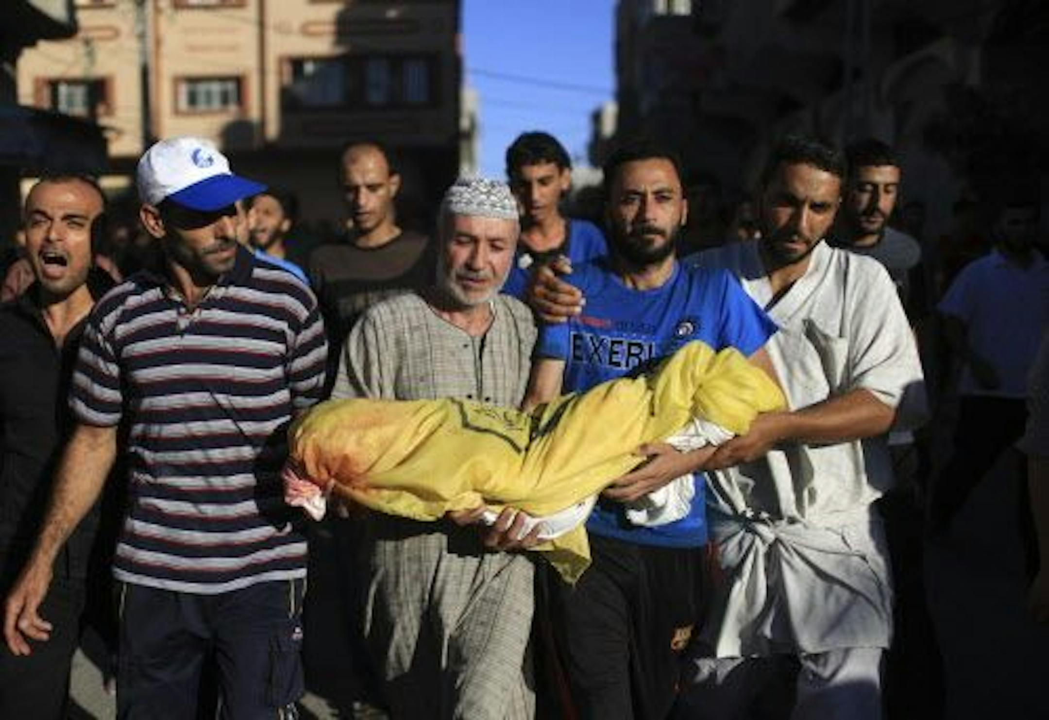 The body of three-year-old Mohammed Abu Namos is carried by mourners in the Jabaliya refugee camp in the northern Gaza Strip, July 11, 2014.